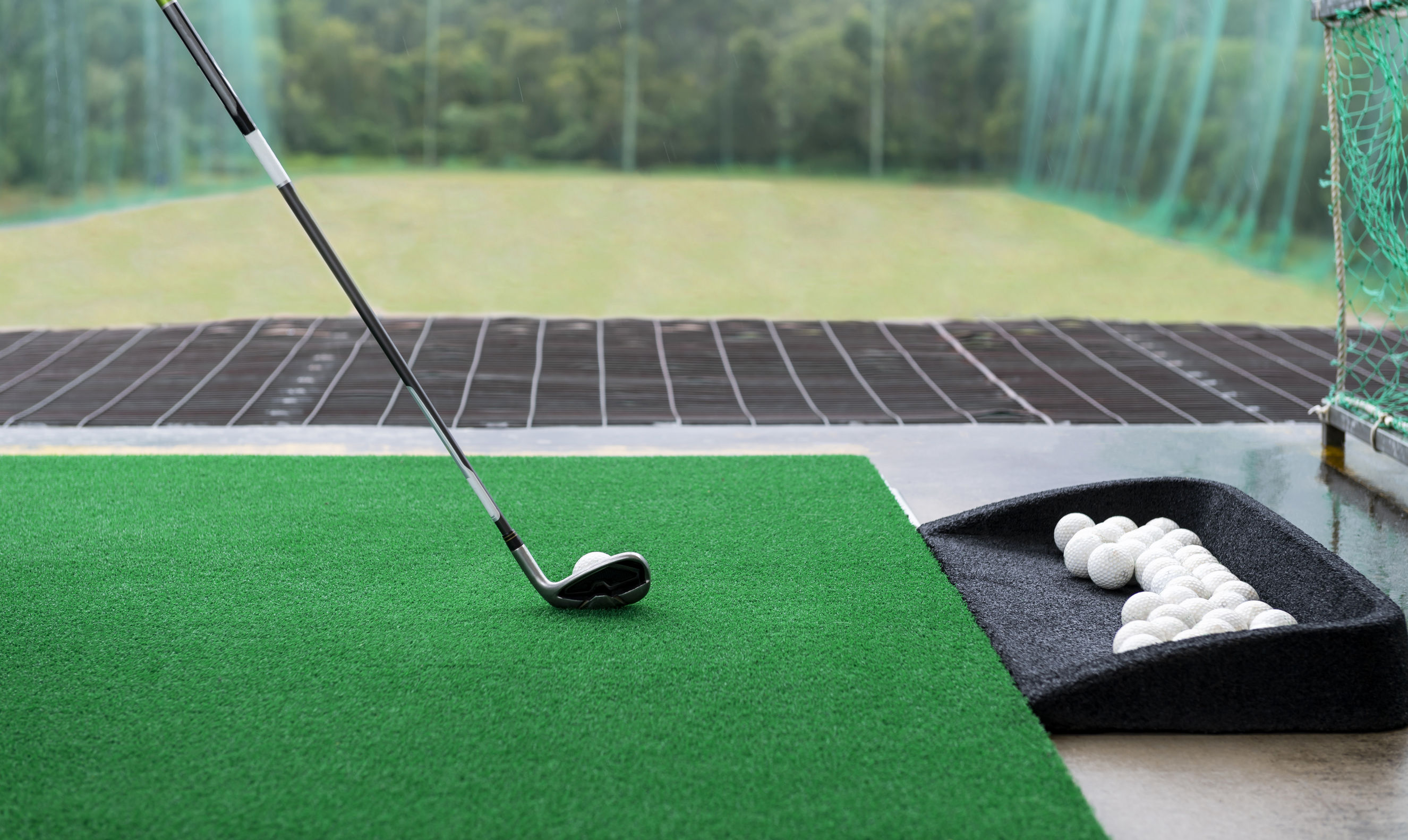 Driving range with golf club and practice balls